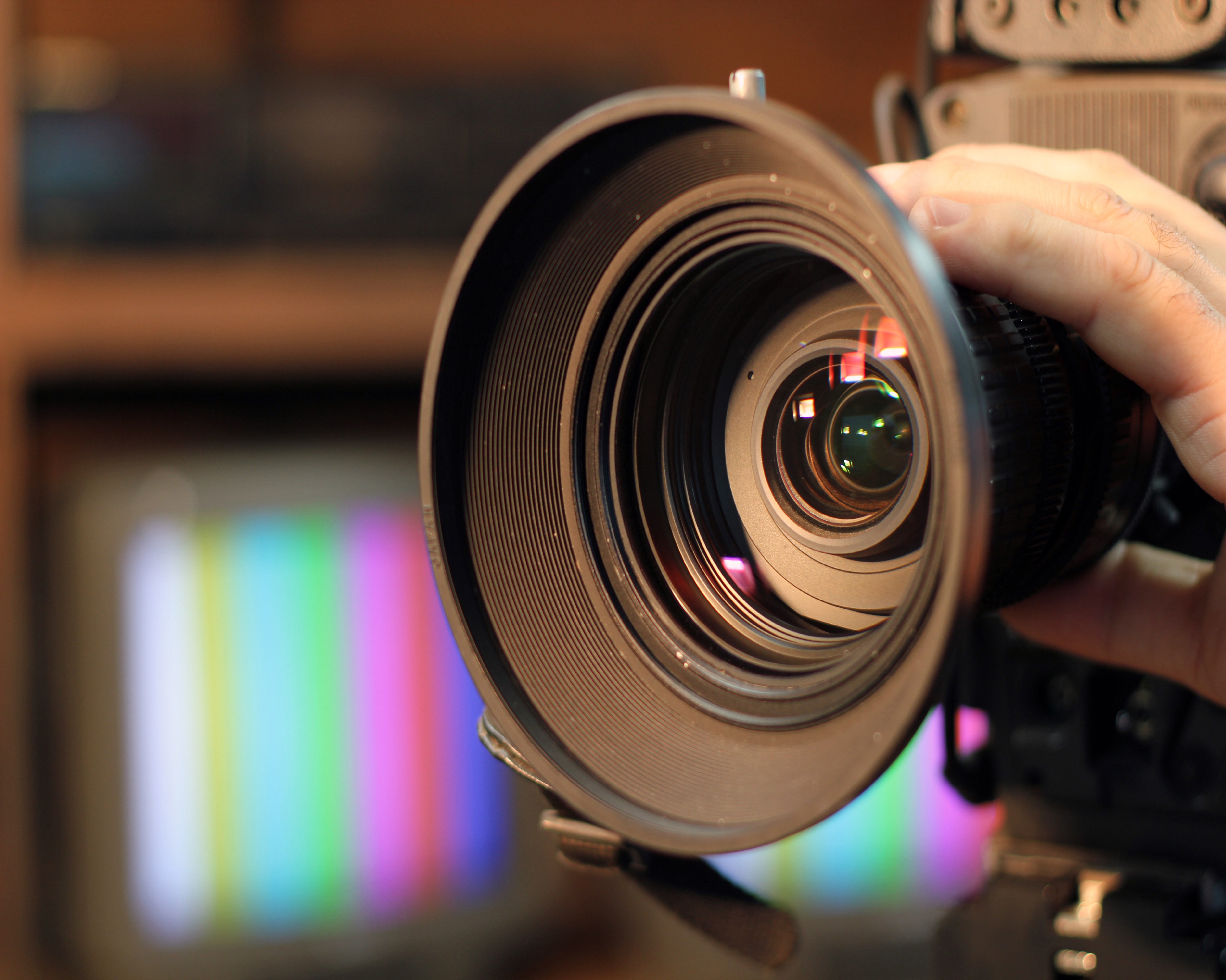 Closeup shot of professional video camera, with its lens zooming in.